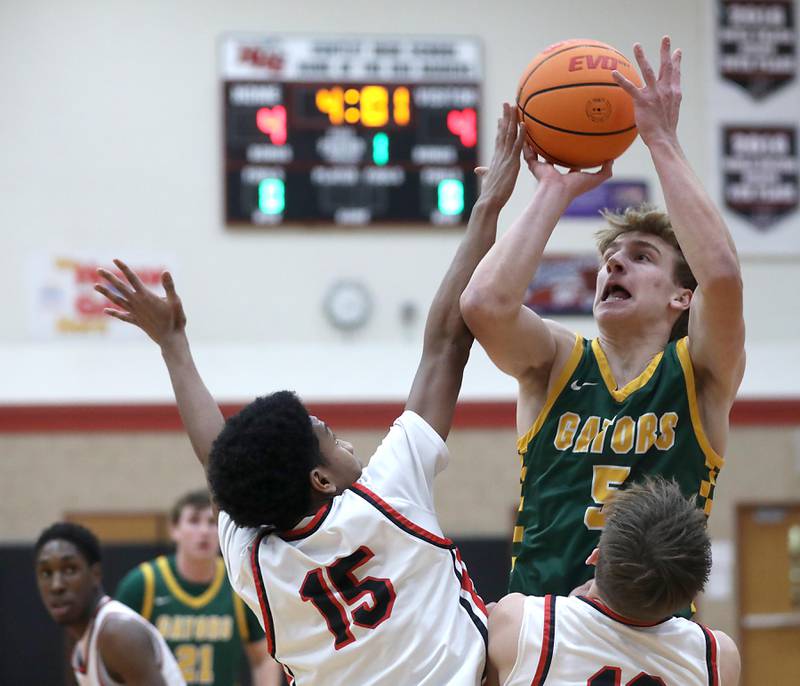 Crystal Lake South's Carson Trivellini (center) shoots the ball over Huntley's Isaac Muze (left) and Tyler Dudzinski (right) during a Fox Valley Conference boys basketball game on Wednesday, Dec. 10, 2025, at Huntley High School.
