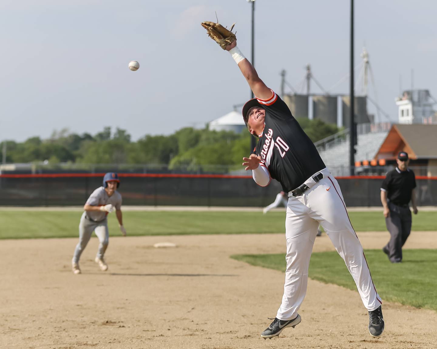 Minooka's Ivan Dahlberg (20) leaps for a ball that gets through for a hit during baseball game between Minooka vs Oswego May 24, 2021.