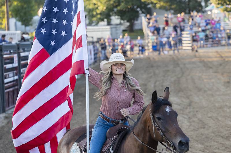 Laynee Noble displays the flag in the ring Tuesday, August 15, 2023 in the Next Level Pro Bull Riding event at the Whiteside County Fair.