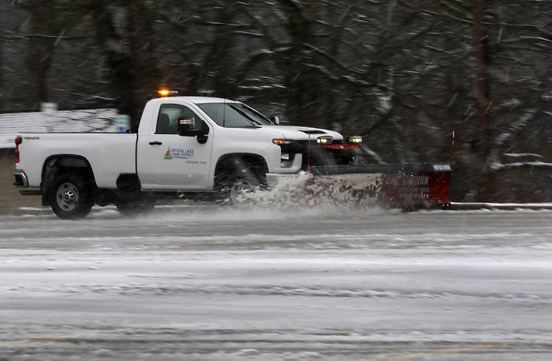 Snow is removed from the parking lot at Veterans Acres Park as a winter storm moves through McHenry County on Tuesday, Jan. 9, 2024, delivering snow to most of the county.