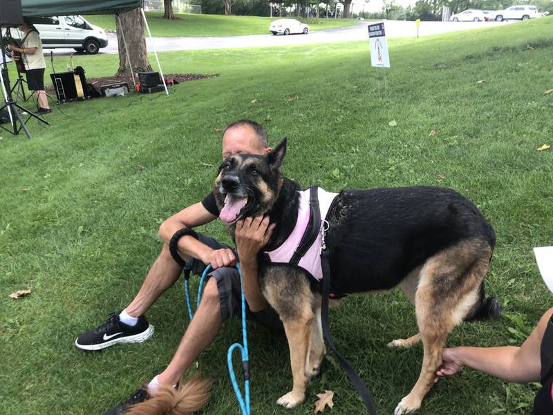 Justin Dambrauskas pets Kona at Pawfest in Huntley Aug. 3, 2024.