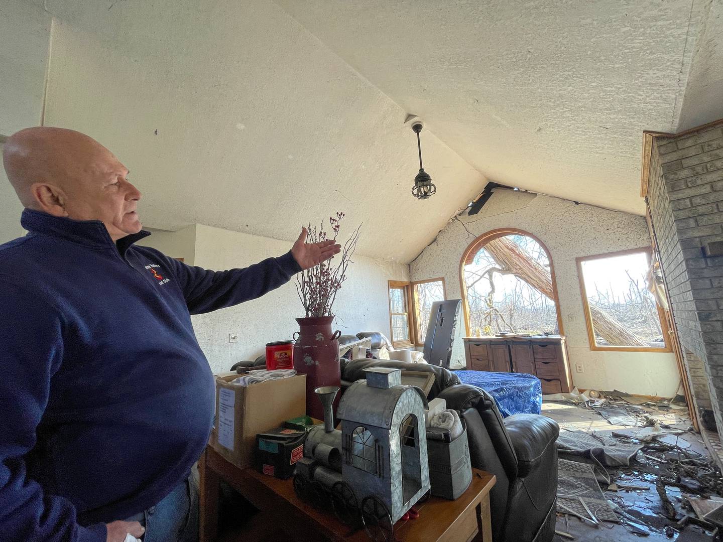Aroma Township resident Tim Pinson talks about the trees no longer standing, and one leaning against the roof, at his home on Elmwood Drive on March 19, 2026 following the March 10 tornado.