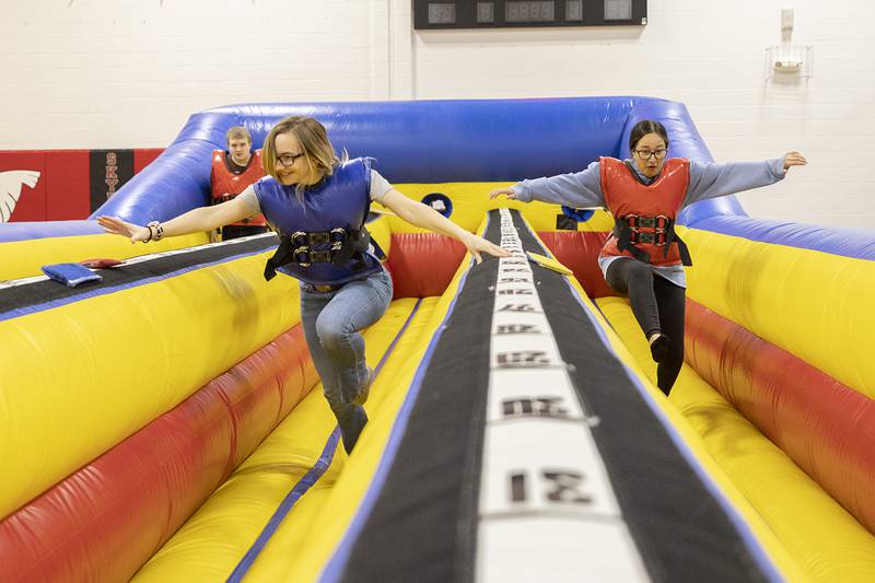 Haliegh Bennett, left, and Allie Royer race one another in a slingshot inflatable during Sauk Valley College’s SaukFest on Wednesday, Feb. 1, 2023.