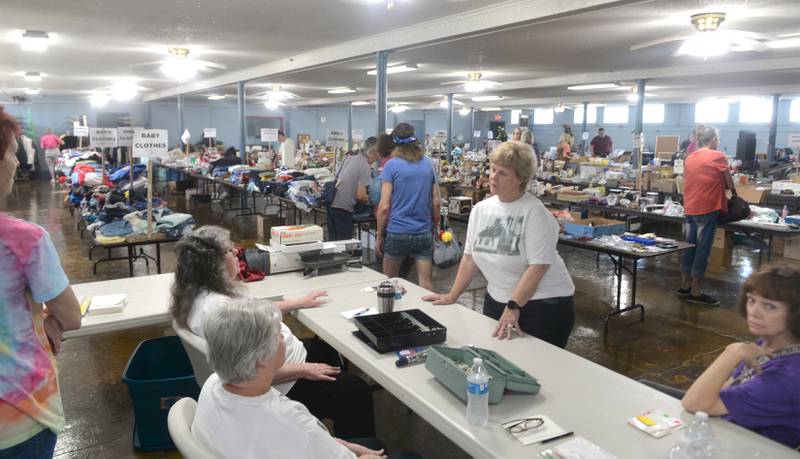 Connie Stauffer, director of the Chana School Museum, talks with volunteers during the Chana School's annual rummage sale on Friday. The sale is being held Friday and Saturday in the basement of the Oregon Coliseum on N. Fourth Street and in tents on the building's front lawn.