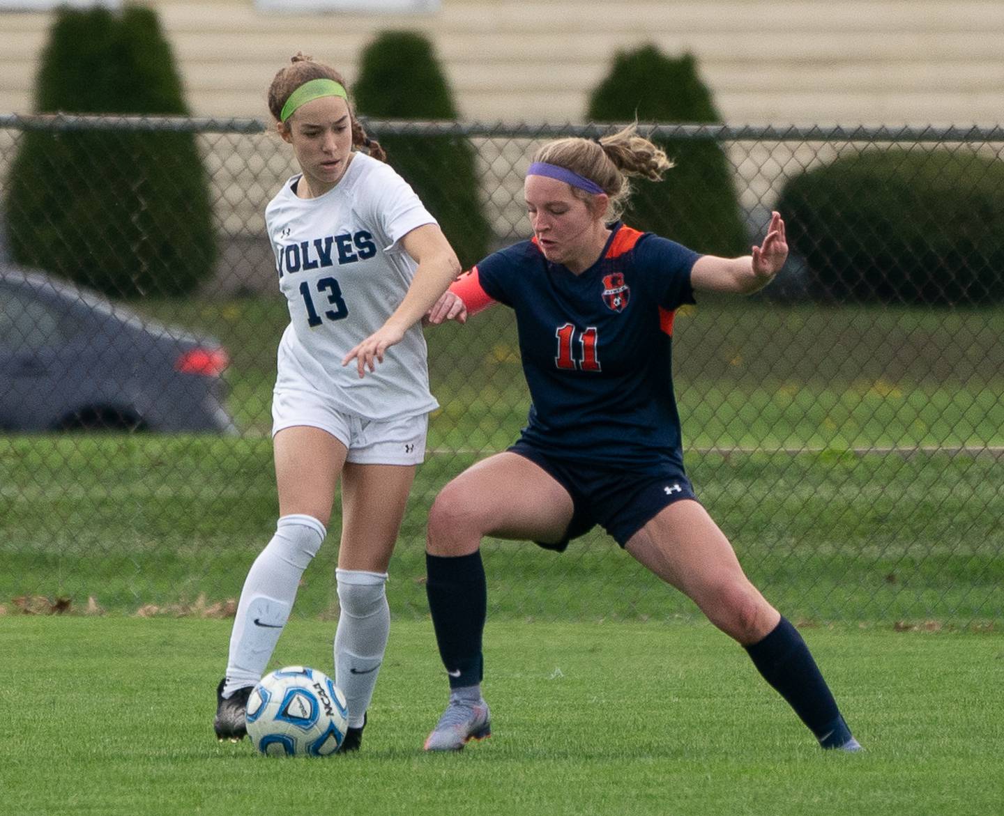 Oswego East's Riley Gumm (13) plays the ball against Oswego’s Elaina Hallick (11) during a soccer match at Oswego High School on Monday, May 2, 2022.