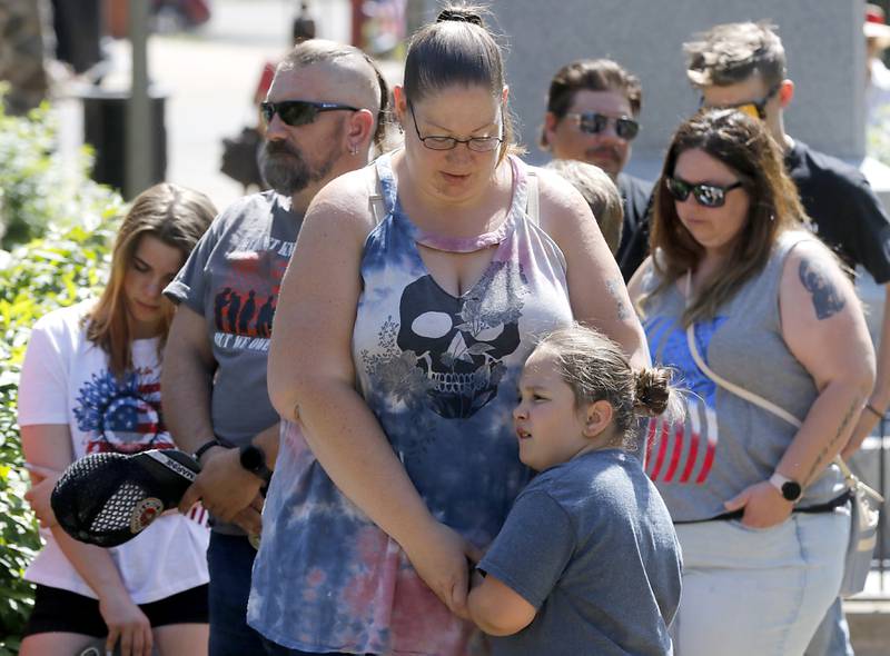 Debbie Bohl of Genova City, hods Josalyn Mack, 7, as the Invocation is delivered by VFW Chaplain Dave Brady during the Woodstock VFW Post 5040 City Square Memorial Day Ceremony and Parade on Monday, May 29, 2023, in Woodstock.