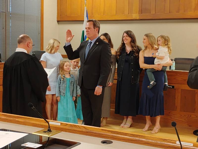 Geneva Mayor Kevin Burns receives the oath of office Monday, May 5, 2025, from Associate  Judge William Engerman, flanked by family, and his partner, Aimee Bychowski.