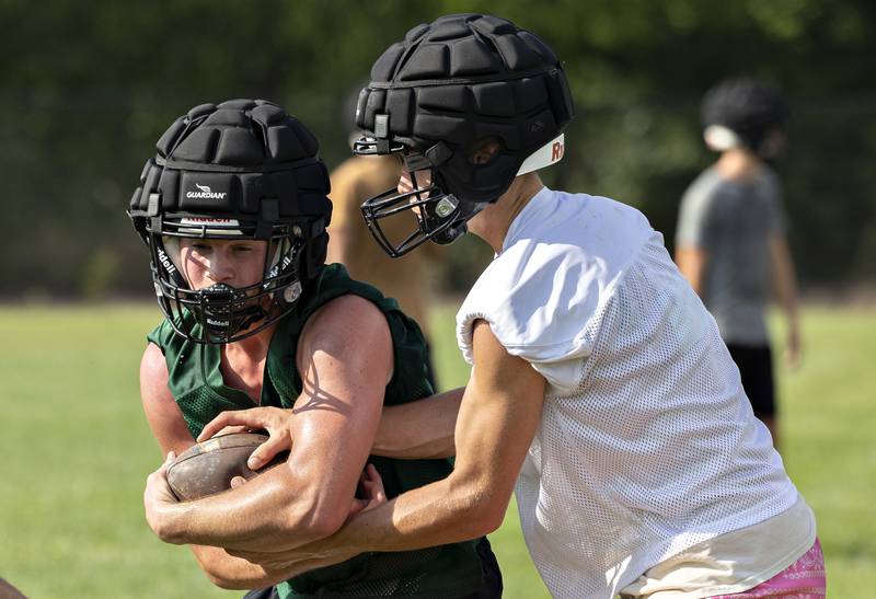 Rock Falls’ Trail Stonitsch takes the handoff from Connor Fritz Tuesday, August 12, 2025. The team hit the gridiron for day two of practices ahead of the 2025 season.
