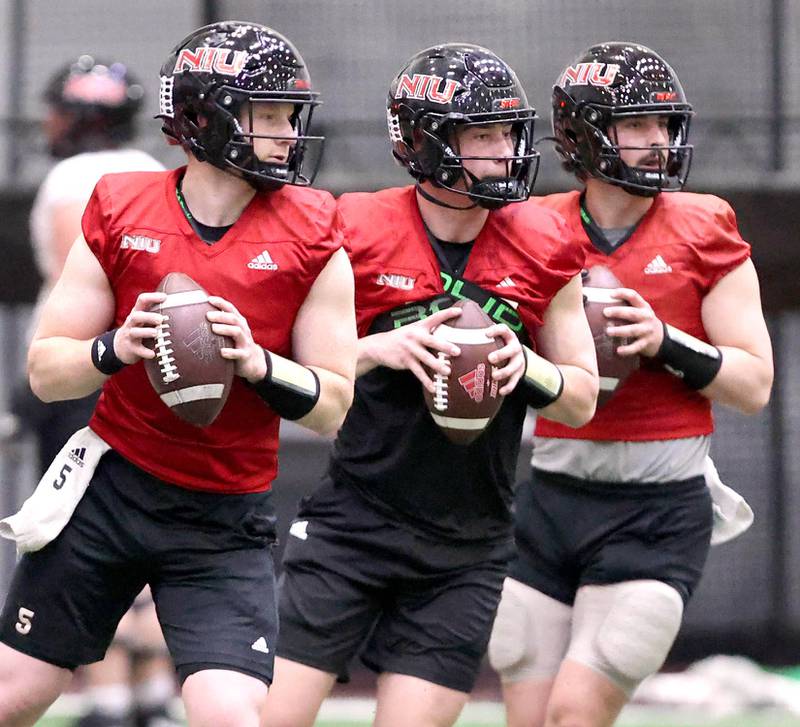 Northern Illinois quarterbacks Justin Lynch, (left) Nevan Cremascoli and Ethan Hampton (right) drop back to pass during the teams first spring practice Wednesday, March 22, 2023, in the Chessick Practice Center at Northern Illinois University in DeKalb.