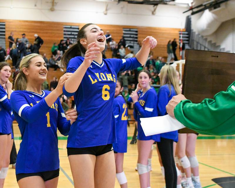 Lyons Township volleyball teammates Kate Heatherly, left and Anabelle Olson (6) receive the regional title plaque after taking the win over York on Thursday Oct. 30, 2025, held at York High School.