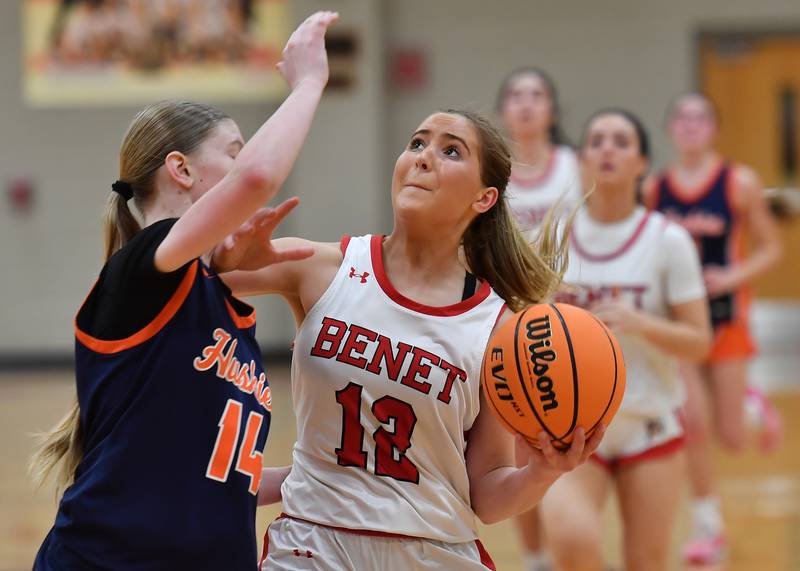 Benet’s Lindsay Harzich goes to the basket as Naperville North’s Sydney Smith (left) defends during the Class 4A Benet Regional championship game on February 20, 2025 at Benet Academy in Lisle.