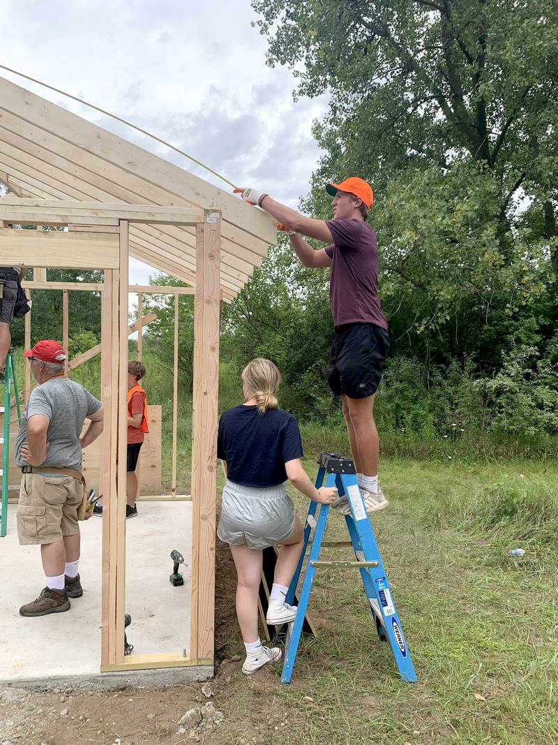Volunteers work with Sugar Grove resident Christopher Eby (on ladder) to replace a dilapidated shed for the Sugar Grove United Methodist Church (SGUMC). The project was Eby’s his Eagle Project for Sugar Grove Boys Scouts of America Troop No. 41.