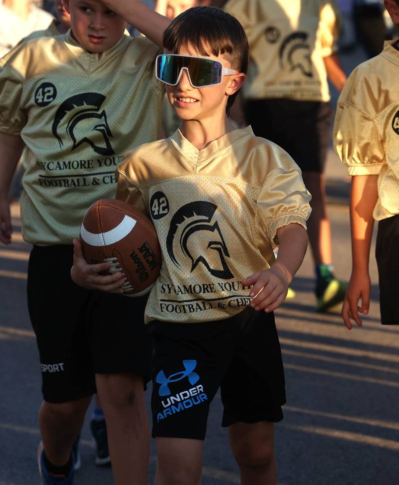 Players in the Sycamore Youth Football and Cheer organization head down State Street Wednesday, Sept. 25, 2024, during the Sycamore High School homecoming parade.