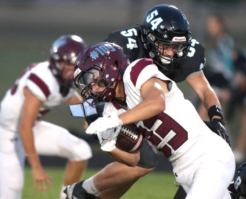 Marengo’s Hunter Muench runs the ball as Woodstock North’s Aaron Christofalos (54) moves in for a tackle in varsity football at Rod Poppe Field on the campus of Marengo High School in Marengo on Friday, Sept. 12, 2025.