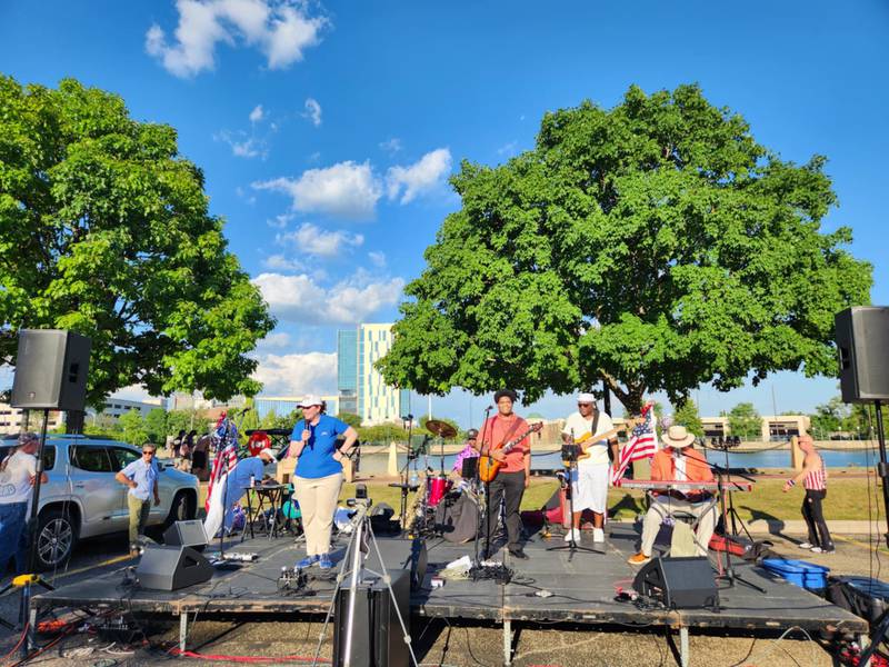 Lori Carmine, manager of the Billie Limacher Bicentennial Park & Theatre in Joliet, introduces the first band on the River Stage - Velvet Rose - at the park's Independence Celebration on Thursday, July 5, 2025, in Joliet.