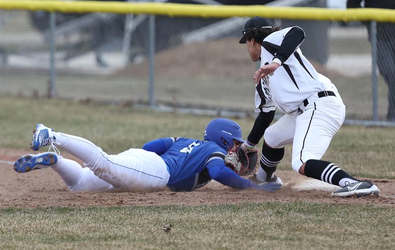 Burlington Central's Mason Rosborough slides back safely as Sycamore's Tommy Townsend applies the tag during their game Tuesday, March 21, 2023, at Sycamore Community Park.