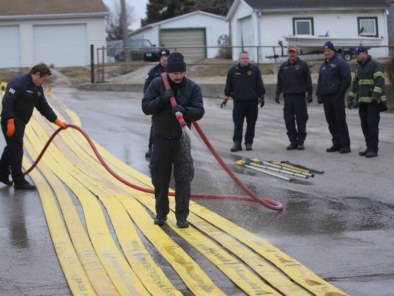 Firefighters from Aurora, Batavia, St. Charles and Big Rock fire departments wash down hoses used in the Carus Chemical fire on Thursday, Jan. 12, 2023 at the La Salle Fire Station