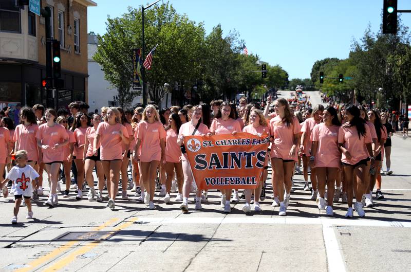 Members of the St. Charles East girls volleyball team walk in the school’s homecoming parade on Main Street through Downtown St. Charles on Thursday, Aug. 31, 2023.