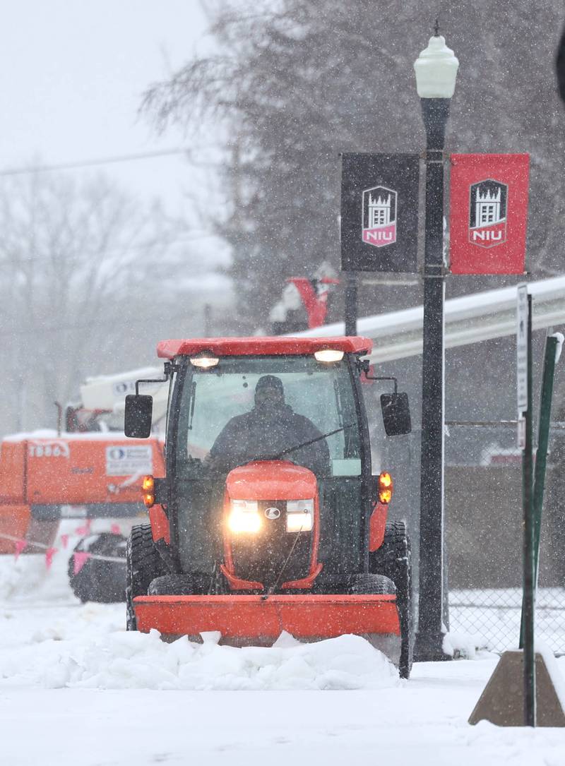 A plow clears the sidewalks and paths Tuesday, Jan. 9, 2024, at Northern Illinois University in DeKalb. Several inches of heavy, wet snow Tuesday was a headache for some and fun for others.
