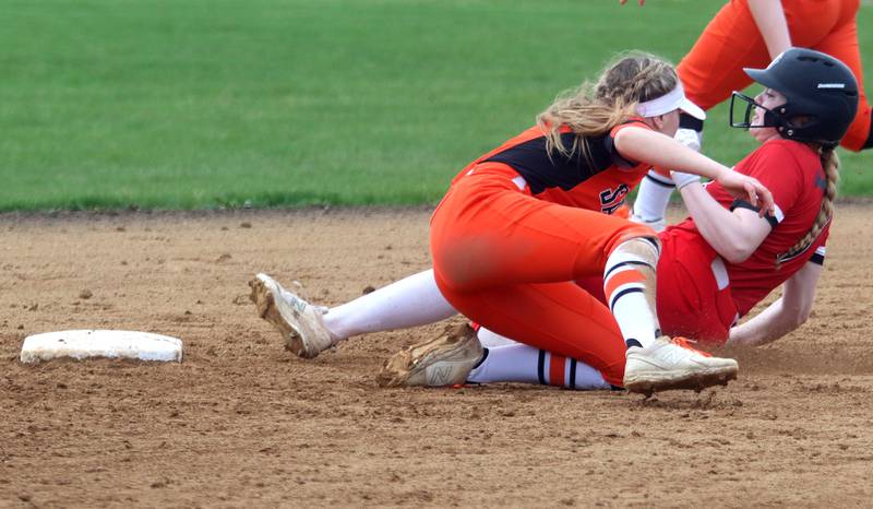 St. Charles East’s Abby Arend, front, tags out Huntley’s Alyssa Ekstrom at second base during varsity softball at Marengo Saturday morning.