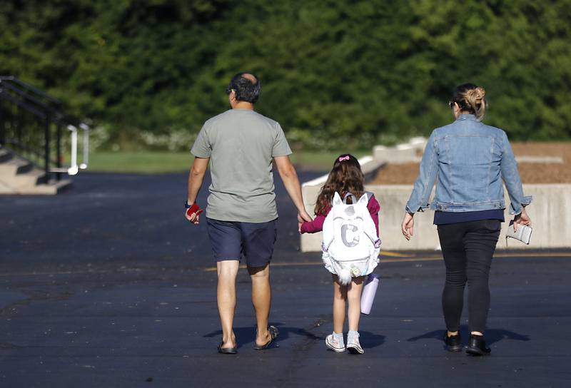 Parents walk their child to the drop-off location for the first day of school at West Elementary School in Crystal Lake on Wednesday, Aug. 16, 2023.
