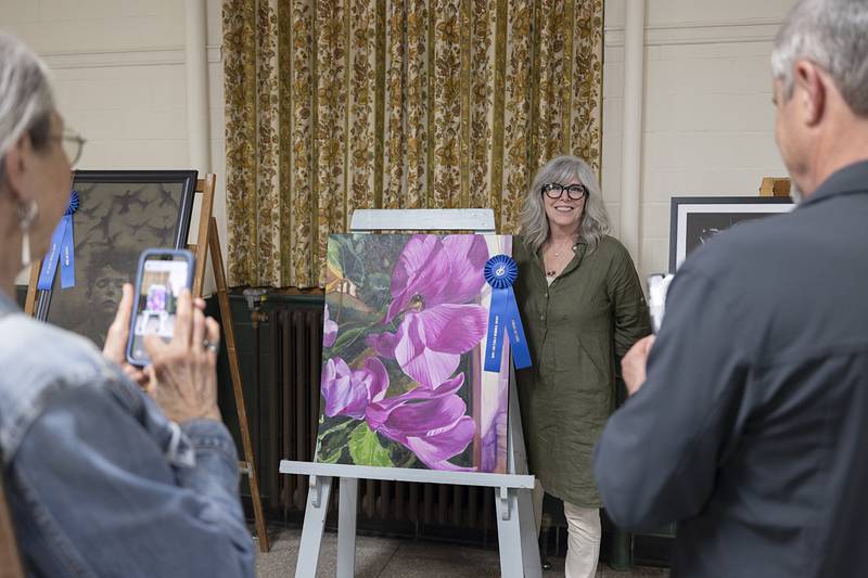 Karen Tucker stands with her award-winning piece, titled “Leanne’s Flower”, on Thursday, April 16, 2026, during the Phidian Art Show awards. Tucker won the Mary Ann Ferolo Award.