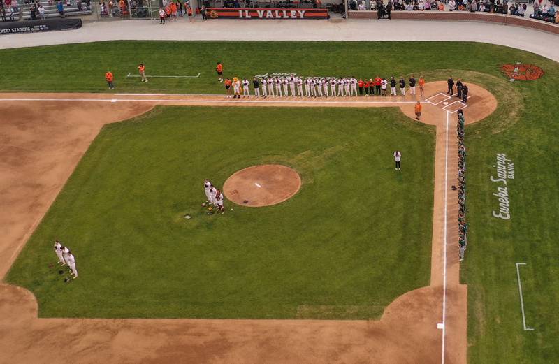Members of the Illinois Valley Pistol Shrimp and Normal Corn Belters stand for the National Anthem during the Illinois Valley Pistol Shrimp home opener on Friday, May 30, 2025 at Schweickert Stadium in Peru.