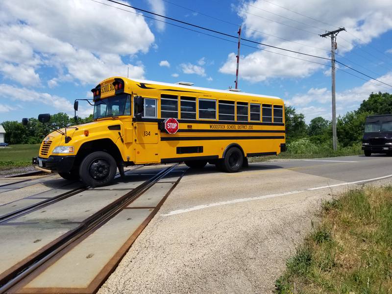 A Woodstock Community Unit School District 200 bus crosses the intersection of Lamb Road and the Metra railroad tracks northwest of Woodstock on Tuesday, June 22, 2021. The rail yard in Crystal Lake may be relocated to that site as part of a federal infrastructure spending program.