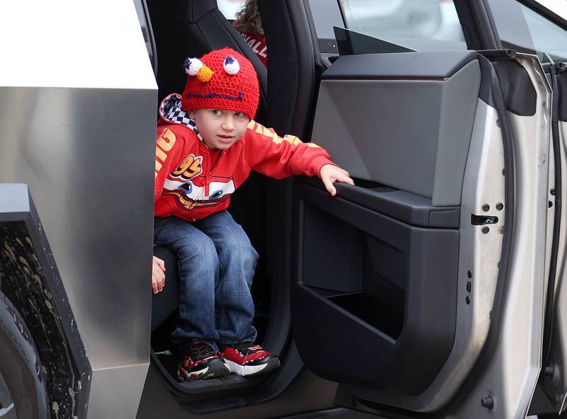 Marshall Morong, 7, a first grader at Hinckley-Big Rock Elementary School, exits his ride Monday, May 5, 2025, as he arrives for his first day back at school after missing months waiting for, and eventually receiving, heart transplant surgery at Lurie Children’s Hospital of Chicago. Morong arrived in style in a Tesla Cybertruck donated for use by Telsa of Naperville, along with an escort by Hinckley and Big Rock first responders.