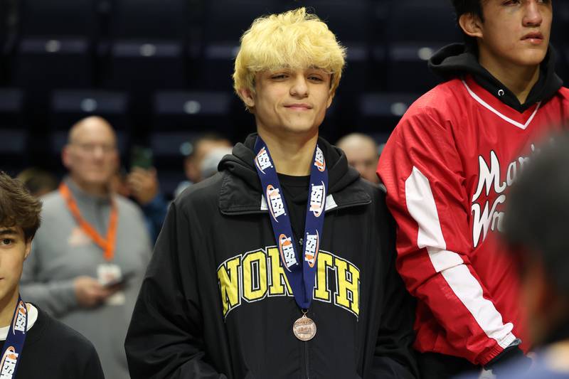 Glenbard North’s Christian Chavez stands on the podium after taking fourth place in the 126-pound Class 3A third place match on Saturday, Feb. 17th, 2024 in Champaign.