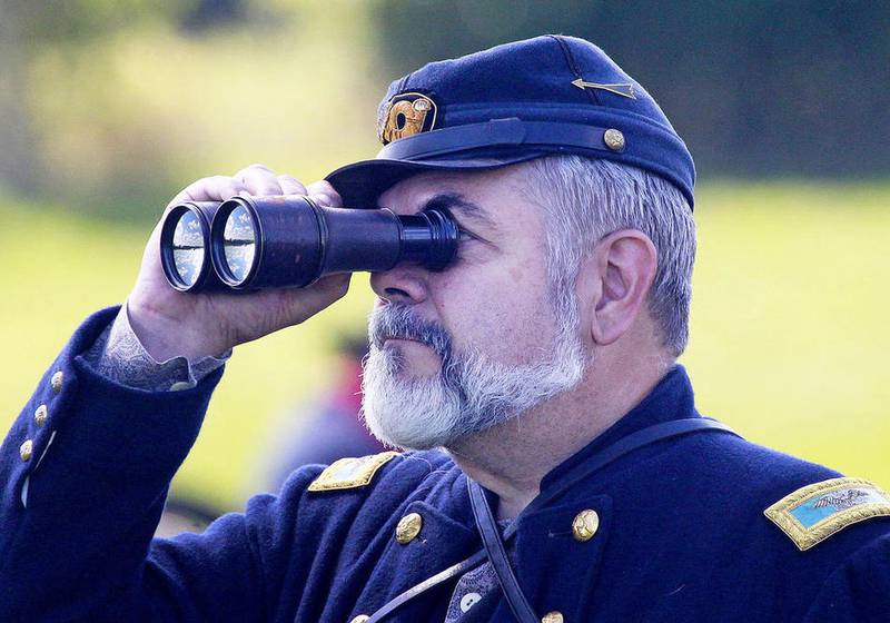 Gerry Morin, of Antioch, a Union general with the Illinois Battalion, looks through his binoculars while his men fight in a skirmish during the Civil War Re-Enactment and Battle at the Northbrook Sports Club in Hainesville.