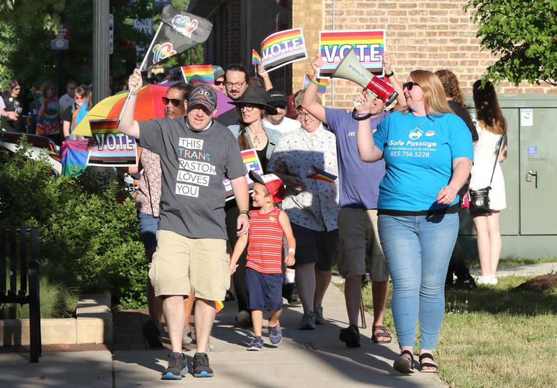 Participants march down the sidewalk on East Locust Street Thursday, June 23, 2022, during a parade to celebrate Pride month in DeKalb. The function included a short parade through downtown and a showing of the movie “Tangerine,” with a panel discussion afterwards at the Egyptian Theatre.