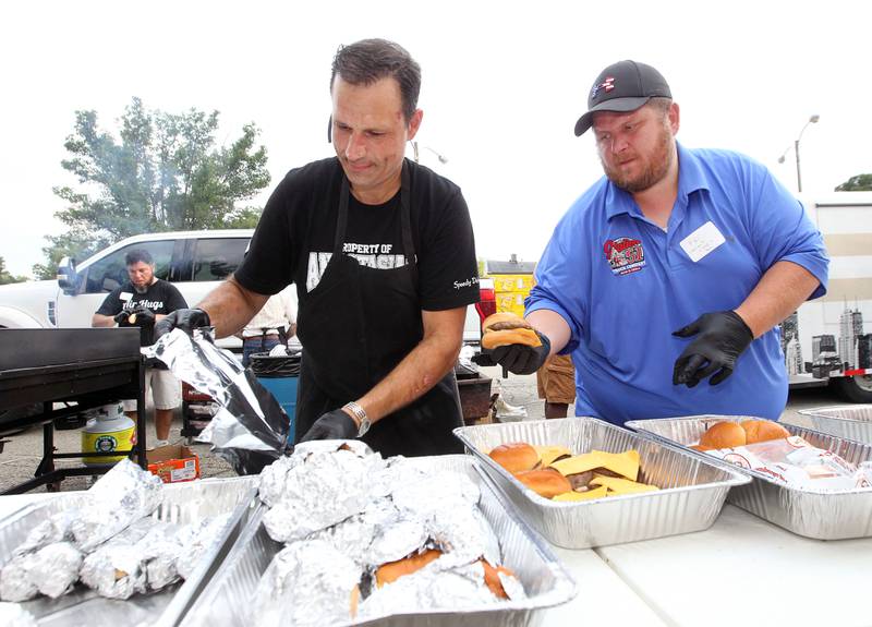 Bill Giannakakis, owner of Anastasia's Restaurant, and Kris Schoenberger, owner of Station 51 Bar & Grill, work together making hamburgers during the final concert of the "It’s Thursday” summer concert series on August 10th in Antioch. The event and its proceeds were dedicated to Huntley, a child who was injured during the Taste of Summer in July. 
Photo by Candace H. Johnson for Shaw Local News Network