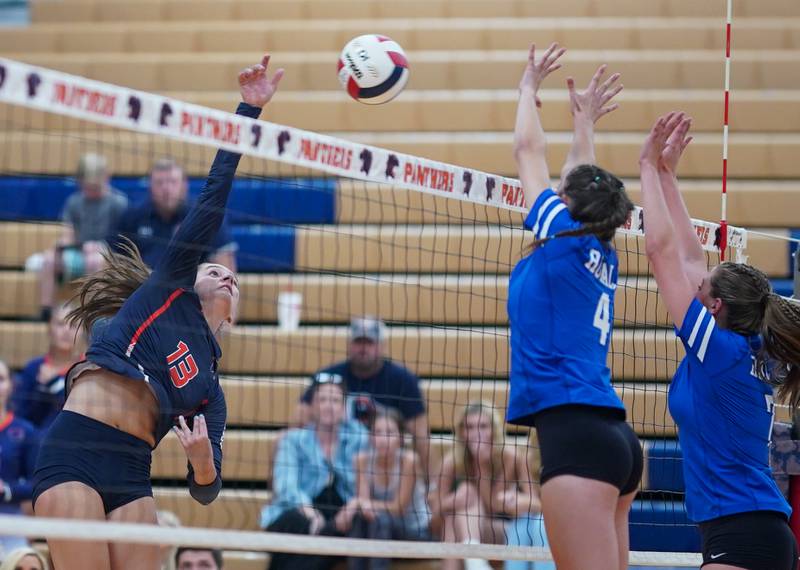 Oswego’s Sidney Hamaker (13) goes up for a kill against Rosary’s Reese Gilla (4) and Molly Lambert (7) during a volleyball match at Oswego High School on Tuesday, Aug 29, 2023.