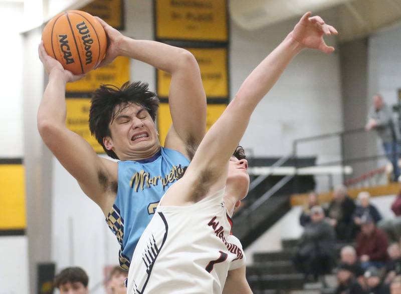 Marquette's Blayden Cassel grabs a rebound over Woodland's Brezdyn Simons during the Tri-County Conference Tournament championship on Friday, Jan. 30, 2026 at Putnam County High School.