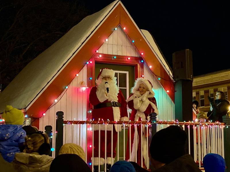 Santa Claus and Mrs. Claus stand outside their house in front of the DeKalb County Courthouse in downtown Sycamore on Friday, Dec. 5, 2025, for the annual Walk with Santa and lighting of the holiday tree.