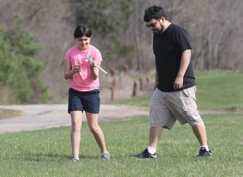 Rosa Lozano, 10, of Lake Villa with the Prince of Peace Rocketeers Team walks with her father, Manuel, after retrieving her eggloft rocket after it just launched at theTim Osmond Sports Complex in Antioch.
