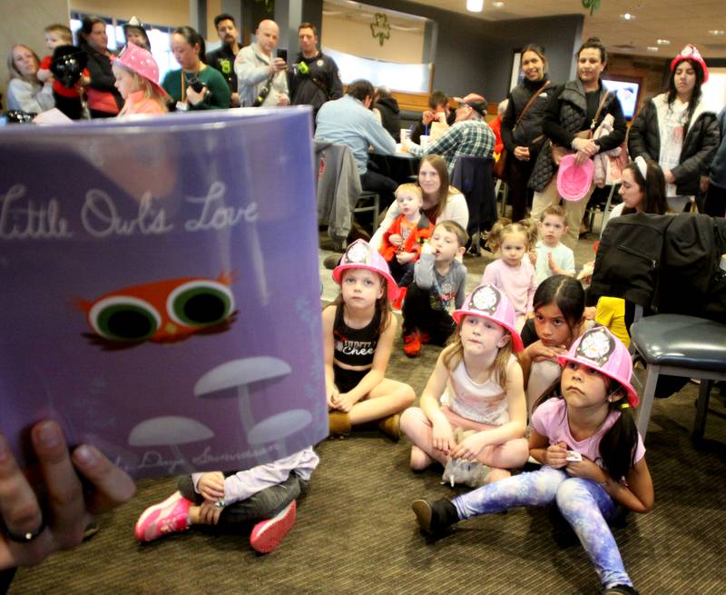 Youngsters listen as Huntley firefighter Brad DeRaedt reads a storybook during a Read & Eat Fries With a Firefighter event Thursday, March 16, 2023, at the Culver’s in Huntley.