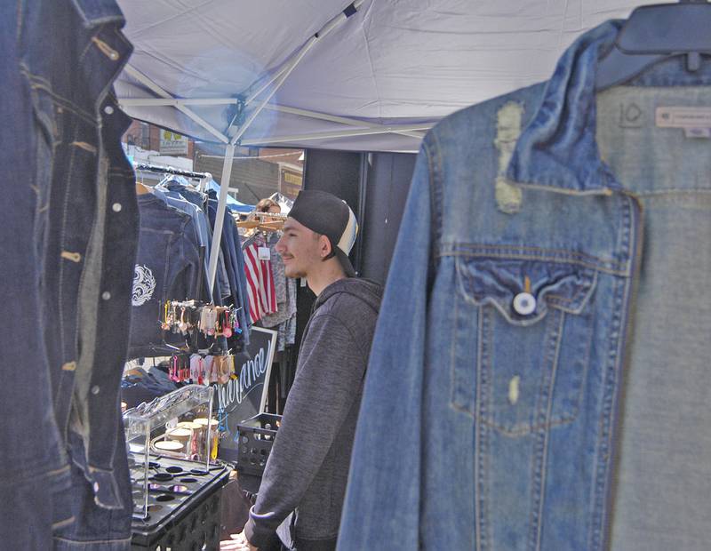 Ezekiel Soukup of Coal Valley listens to a customer at his booth at the Great River Tug Fest across the Mississippi River on Saturday, Aug. 10, 2024.