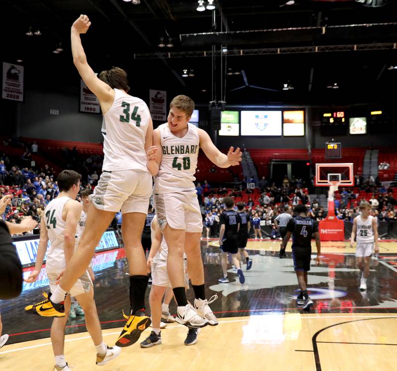 Glenbard West’s Braden Huff (34) and Jack Oberhofer (40) celebrate their Class 4A DeKalb Supersectional game win over Larkin at the Northern Illinois University Convocation Center on Monday, March 7, 2022.