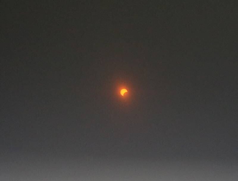 Looking through eclipse glasess you can see a crescent sun as the moons shadow partially blocks it on Monday, April 8, 2024 at Rend Lake.