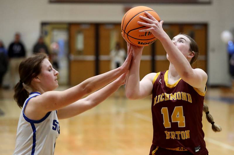 Richmond-Burton's Lilly Kwapniewski (right) drives to the basket against Woodstock's Emma Douglas during a Kishwaukee River Conference girls basketball game on Wednesday, Jan. 28, 2026, at Woodstock High School.