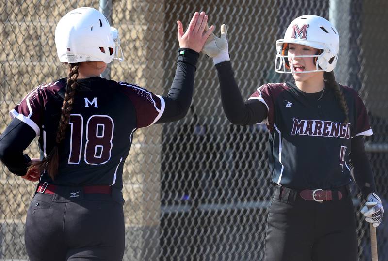 Marengo's Alyssa Pollnow (left) is congratulated after scoring a run by Josephine Christiansen Friday, April 11, 2025, during their game at Sycamore High School.