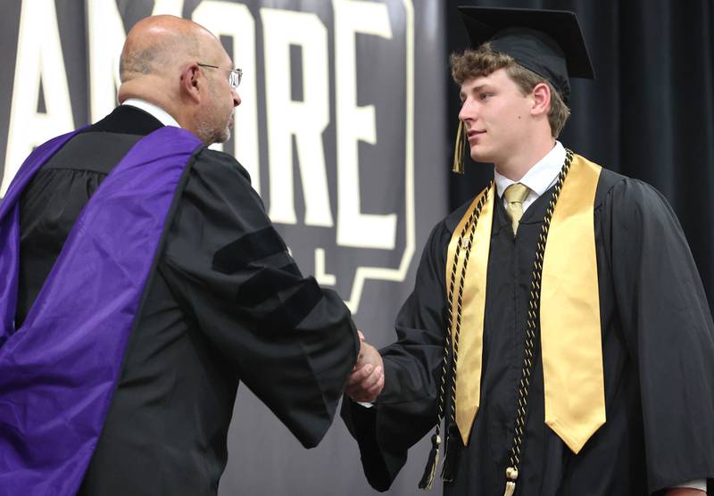 Ethan Bode is congratulated by Board of Education President James J. Dombek as he receives his diploma during commencement ceremonies Sunday, May 28, 2023, at Sycamore High School.