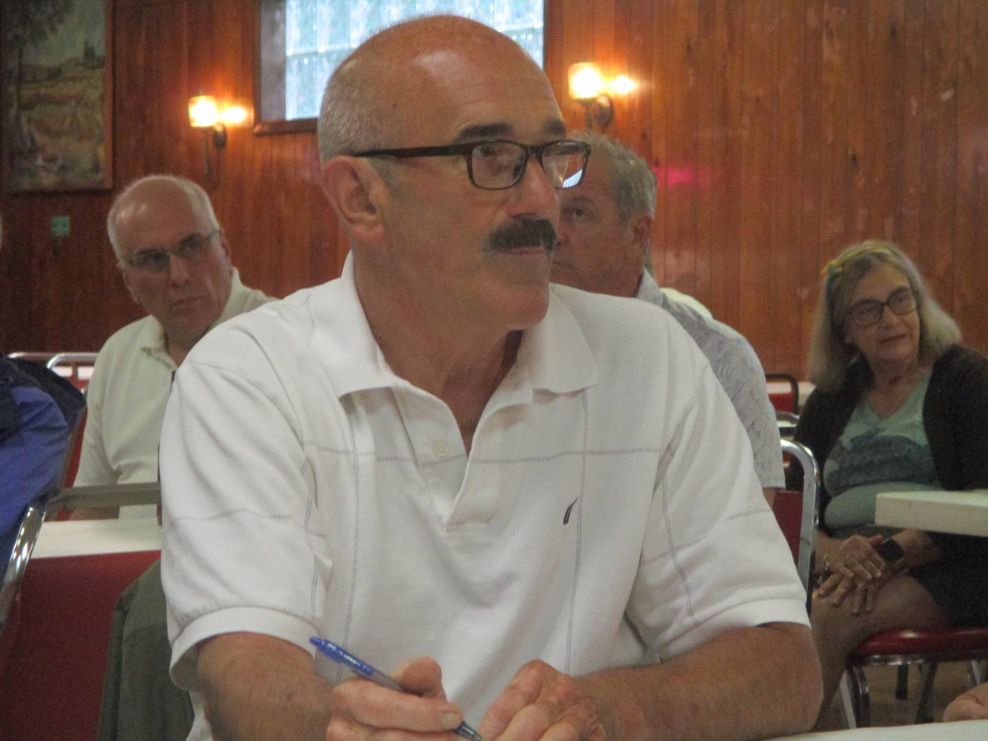 Joliet Catholic Academy board member William Bayci takes notes during a neighborhood meeting on stadium plans for the school on Wednesday. June 18, 2025