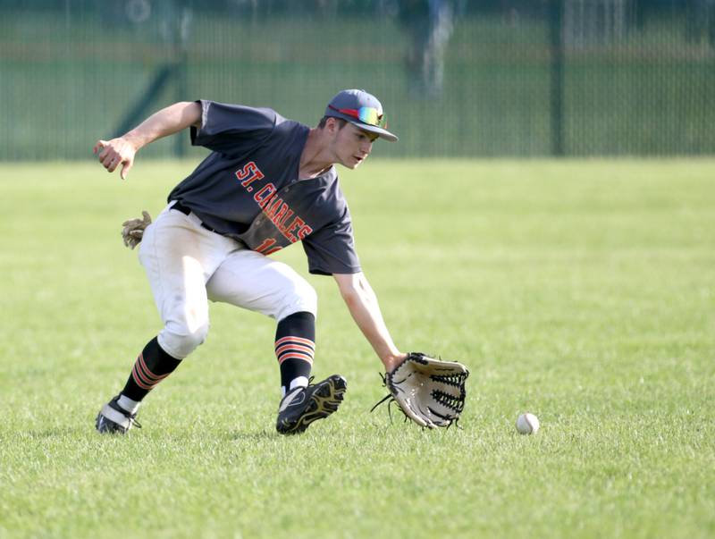 St. Charles East’s Mike Sharko scoops up a ground ball in the outfield during a home game against Wheaton North on Monday, May 15, 2023.