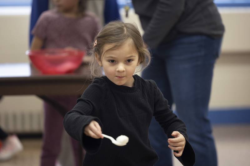 St. Anne’s kindergartener Rowan Newman carries a cotton ball across the room as part of a relay race Tuesday, Jan. 30, 2024. St. Anne’s spent a few hours of fun for the day in celebration of Catholic Schools Week.