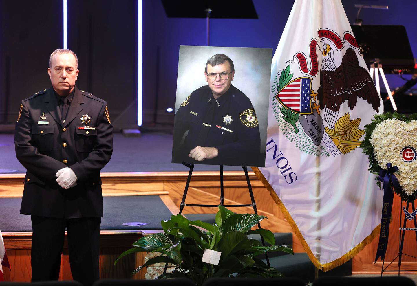 A DeKalb County sheriff's deputy guards the casket of former DeKalb County Sheriff Roger Scott as a photo of Scott stands nearby during his visitation Thursday, March 6, 2025, at Bethany Road Bible Church in DeKalb. Scott, who was the county sheriff for more than 30 years, died on February 23 at the age of 78.