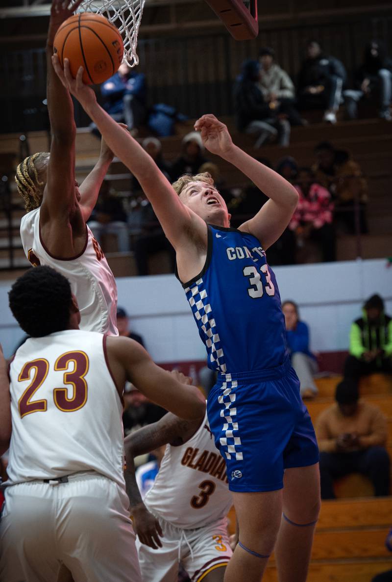 Clifton Central's Jake Thompson, right, looks to put a shot in from behind the net during a game against Christ the King in the Kankakee Holiday Tournament at Kankakee High School on Saturday, December 27, 2025.