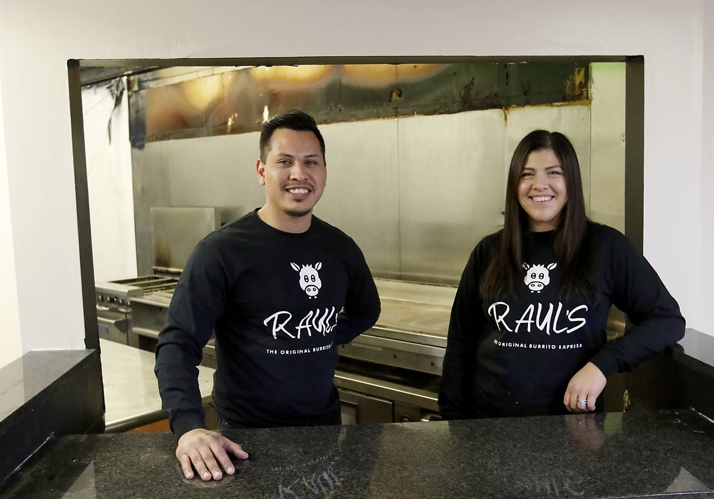 Raul Briseno Jr., and his sister Alexandra Strohmaier, the children of the late Raul Briseno Sr., stand behind the counter of their father’s first restaurant on Tuesday, Feb. 22, 2022. They are opening a restaurant in the original location where their dad opened up his first Raul’s Burrito Express in Wauconda. It has been 21 years since his father was murdered at the Burrito Express he owned in McHenry.